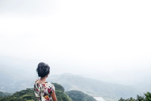 在斯里兰卡马塔莱，一名妇女正享受着薄雾丘陵的宁静景色