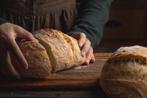 Free A Person Holding a Crusty Loaf of Bread  Stock Photo