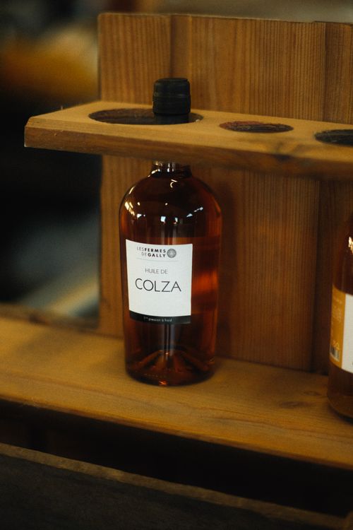 Free Close-up of a bottle labeled 'Huile de Colza' on a wooden shelf. Stock Photo