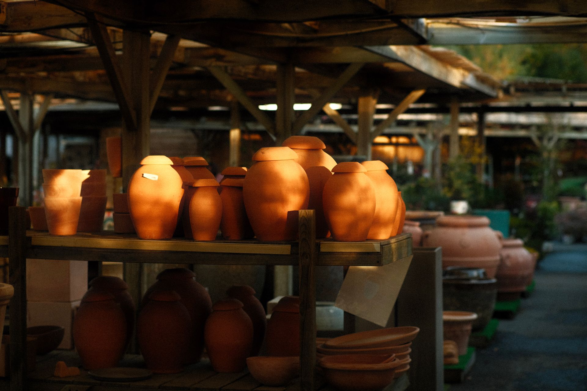 Beautiful handmade terracotta pots displayed on shelves in an outdoor market, showcasing artisanal craftsmanship.