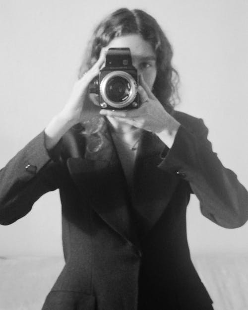 
A Grayscale of a Woman Holding a Camera