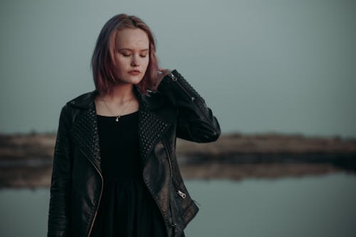 Woman in Black Leather Jacket Standing Near Body of Water