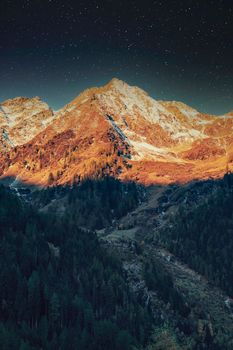 Majestic mountain range under a starry sky, perfect for travel and nature themes.