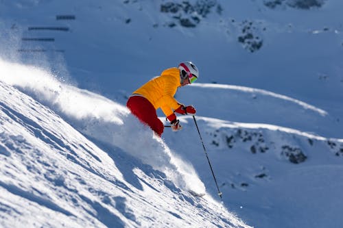 Free Person in Red Jacket and Blue Pants Riding on Ski Blades on Snow Covered Mountain during Stock Photo