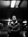 Man in Black Jacket Standing in Grayscale Photography