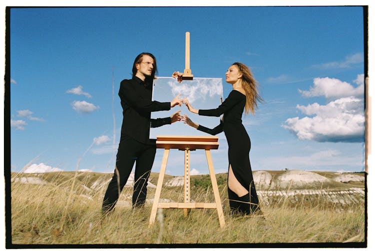 Reflection Of Woman And Man Hands In Frame On Grass