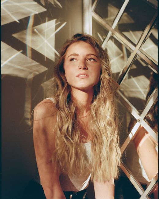Portrait of a young woman with blonde hair in a sunlit room, Moscow.