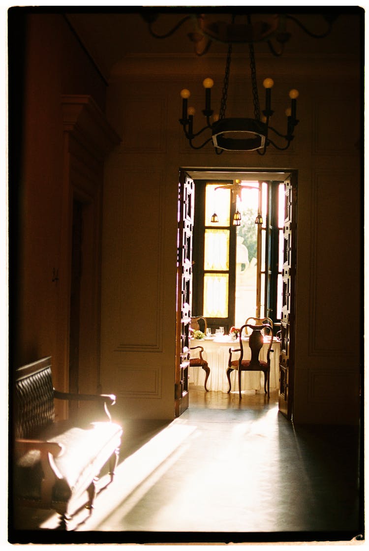 Light Shining Into Dark Hallway From Bright Dining Room