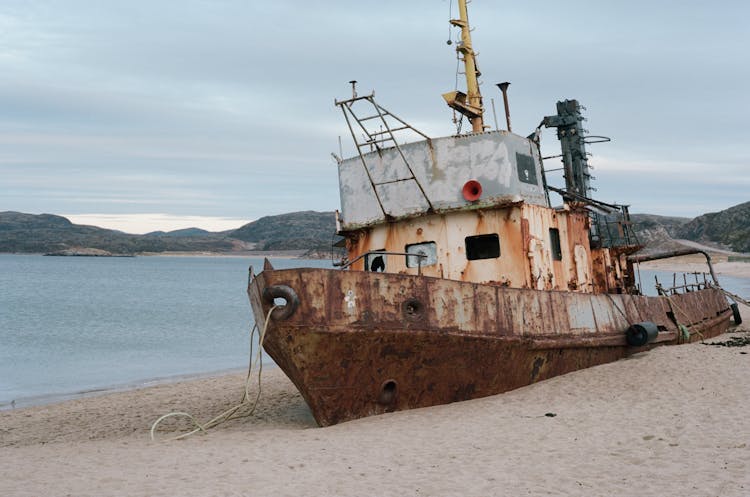 Photo Of An Abandoned Ship At The Beach