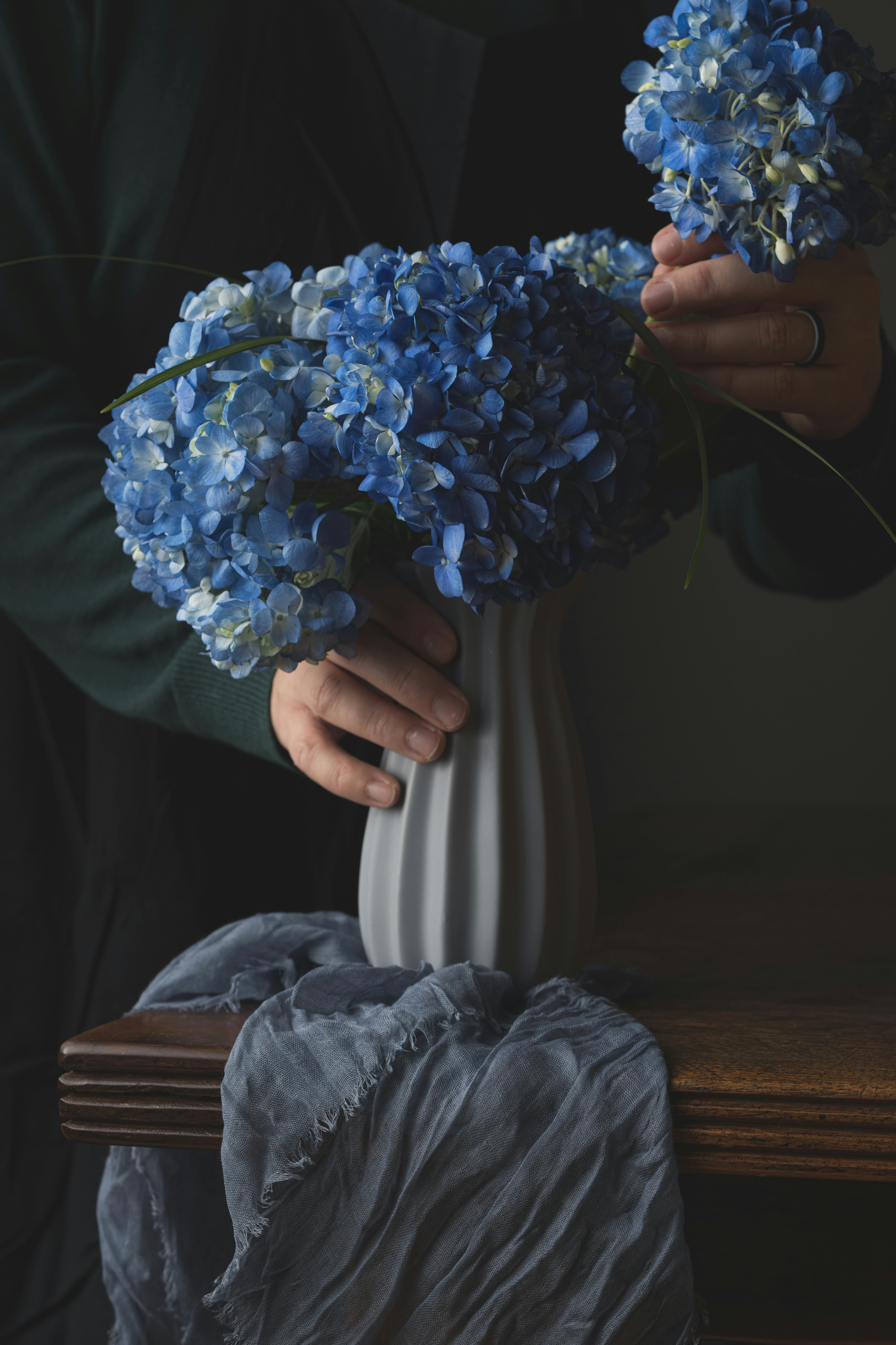 Mujer Con Tatuaje De Flor Negra Y Roja De Pie Detrás De Flores Azules · Foto de stock gratuita Mujer Con Tatuaje De Flor Negra Y Roja De Pie Detrás De Flores Azules · Foto de stock gratuita