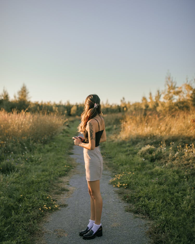 Woman On Footpath At Sunset