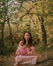 Woman Sitting in Park and Blowing Candle on Muffin
