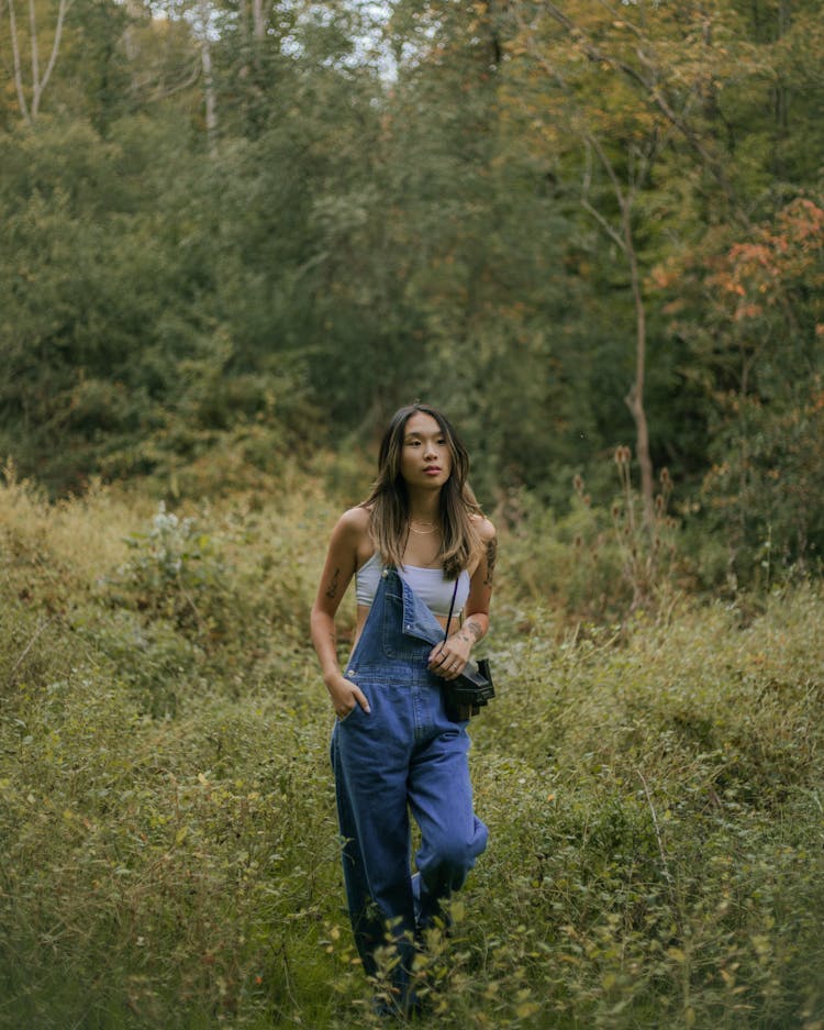 Woman In Dungarees Walking Through Park