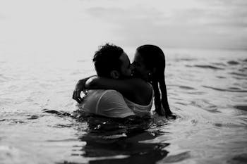 Man and Woman Kissing Together on Body of Water