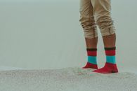 Person Wearing Red Socks Standing on Sand
