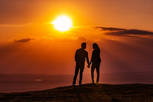 Silhouette of Couple Standing on Mountain during Sunset