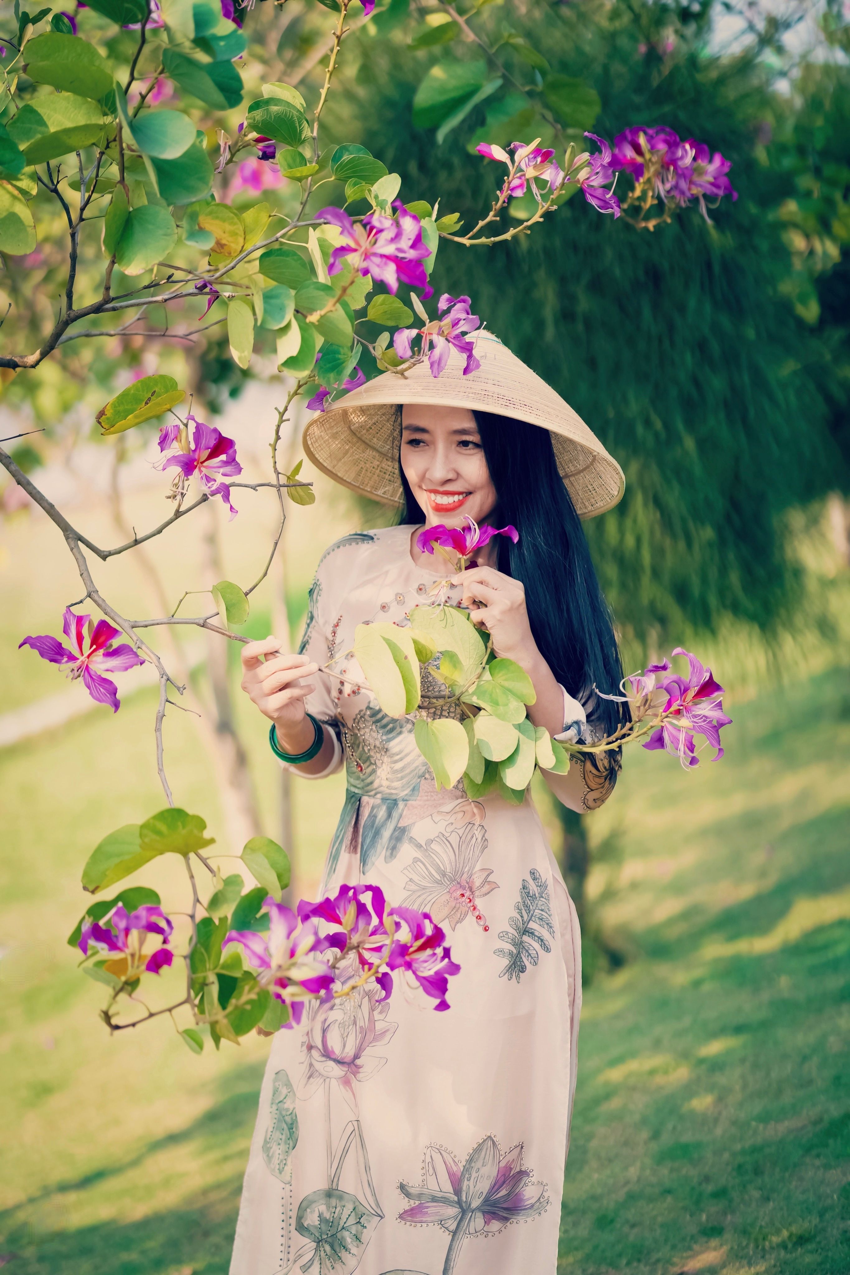 A Woman Wearing Floral Dress and a Straw Hat Holding Flowers from the ...