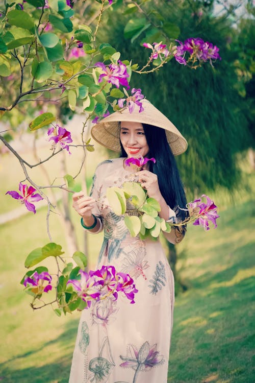 Kostnadsfri bild av asiatisk kvinna, blommig klänning, blommor