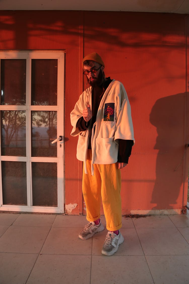 A Man In White Robe Standing Near The Door With Glass Panels