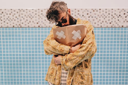 A Bearded Man Embracing a Brown Paper Bag