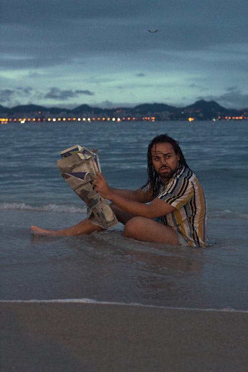 Man with Newspaper Sitting in Water