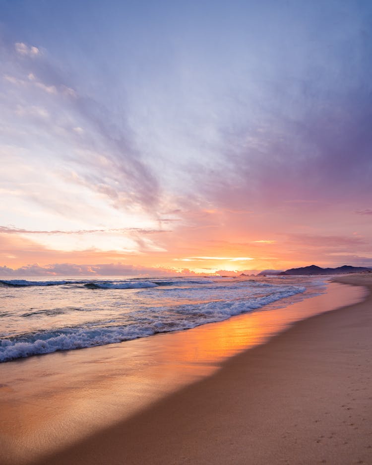 Sea Waves Crashing On Shore During Sunset