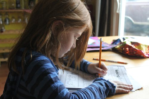 Free Girl Drawing On Brown Wooden Table Stock Photo