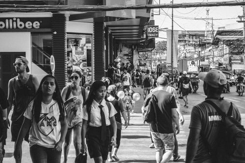 Free Black and white busy street scene in Dumaguete, featuring diverse pedestrians and urban life. Stock Photo