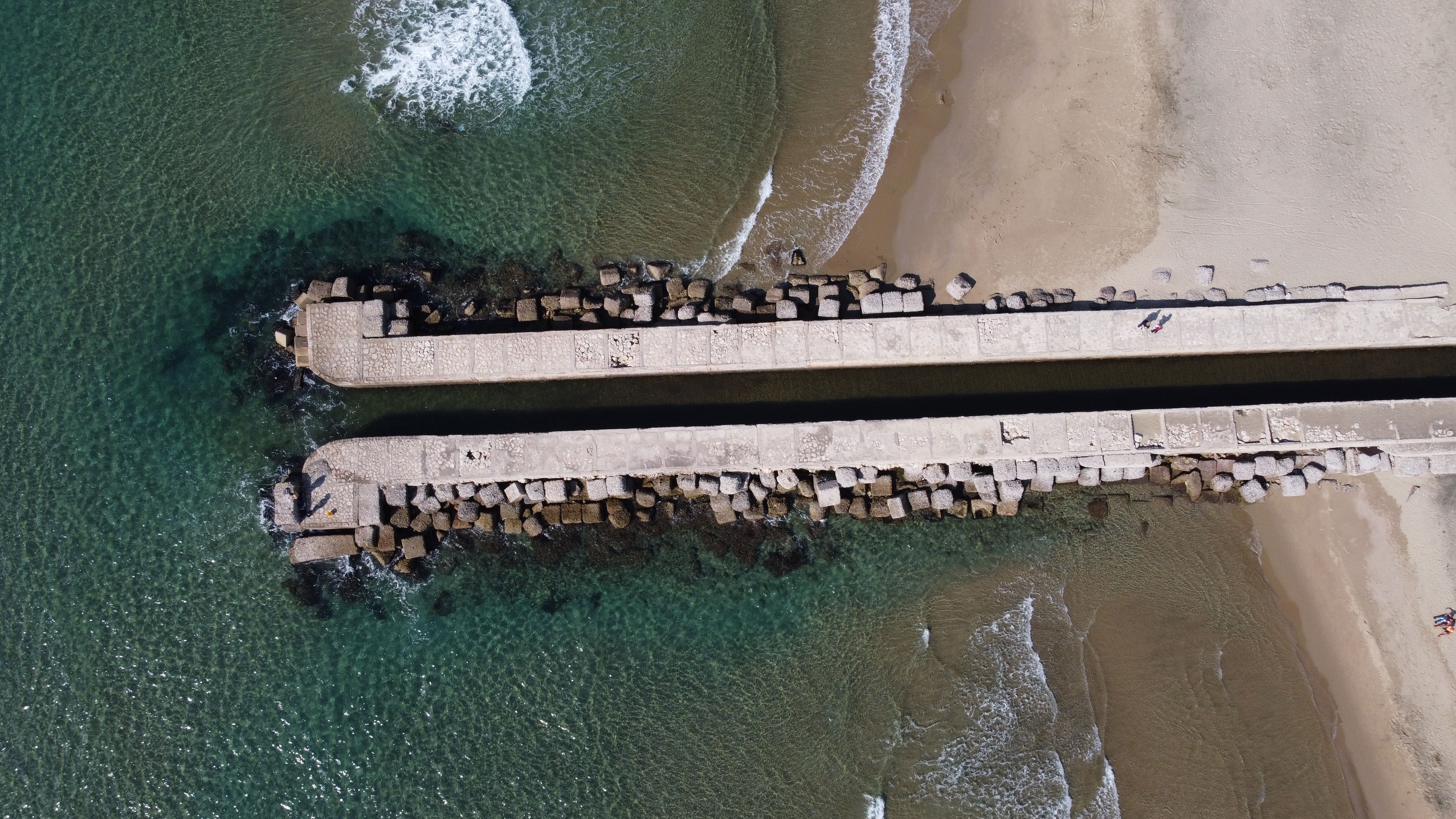 Aerial perspective of a concrete pier extending into the sea at Anzio's coastline in Italy. - Photo by Arnis Rascal on Pexels