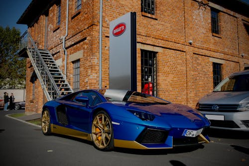 Free Blue Lamborghini Parked Near Brown Brick Building Stock Photo