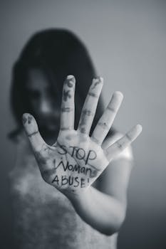 A dramatic black and white photo emphasizing a strong message against woman abuse.