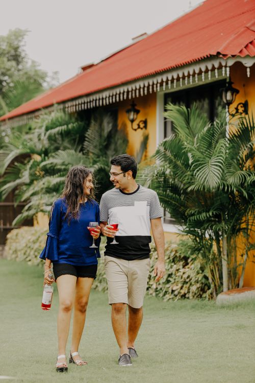 Free A couple enjoying a walk with wine outside a colorful Indian house. Stock Photo