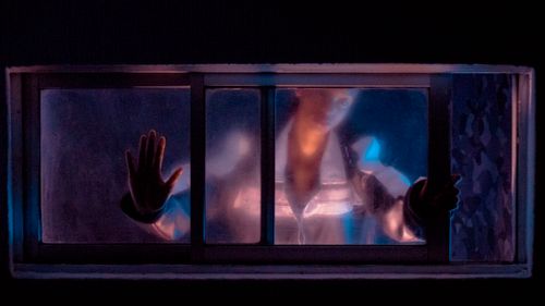 Free A silhouette of a woman behind a frosted glass, creating a mysterious ambiance. Stock Photo
