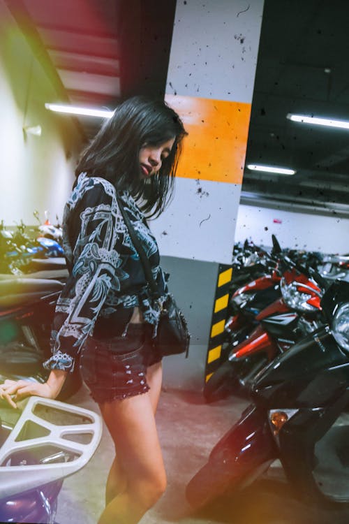 Photography of a Woman Near Motorcycles