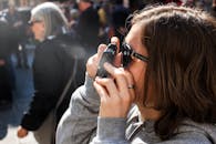 一名年轻女子在佛罗伦萨繁华的街道上拍照，捕捉热闹的气氛