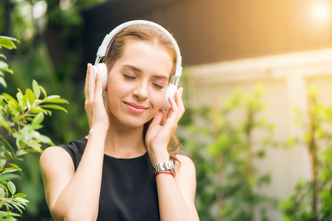 Image of a woman listening to music through headphones.
