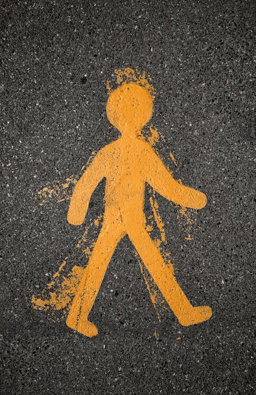 Yellow Pedestrian Safety Sign Painted on Asphalt Road