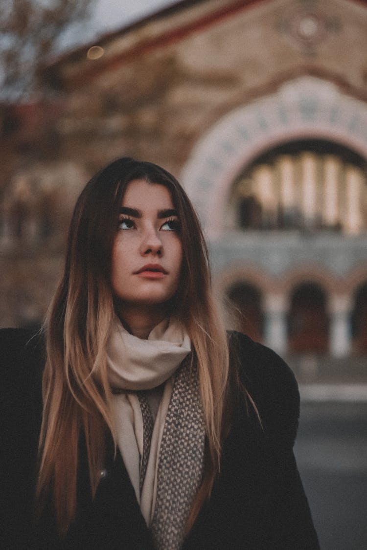 Portrait Of Woman Dressed In Warm Clothes Looking Up