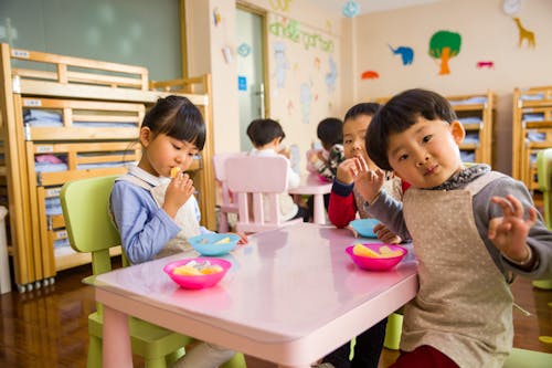 Gratis Tres Niños Pequeños Comiendo En Mesa Blanca Foto de stock