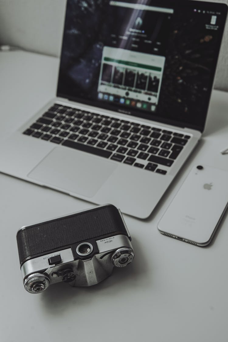 Analog Camera, Laptop And Phone On Desk