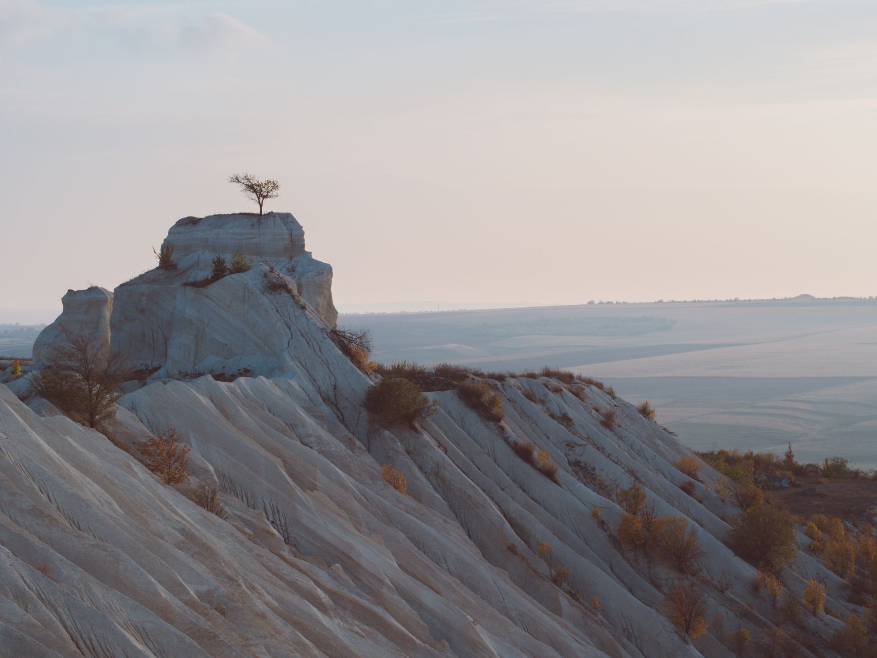 Breathtaking view of an eroded limestone hill with sparse vegetation in Moldova.