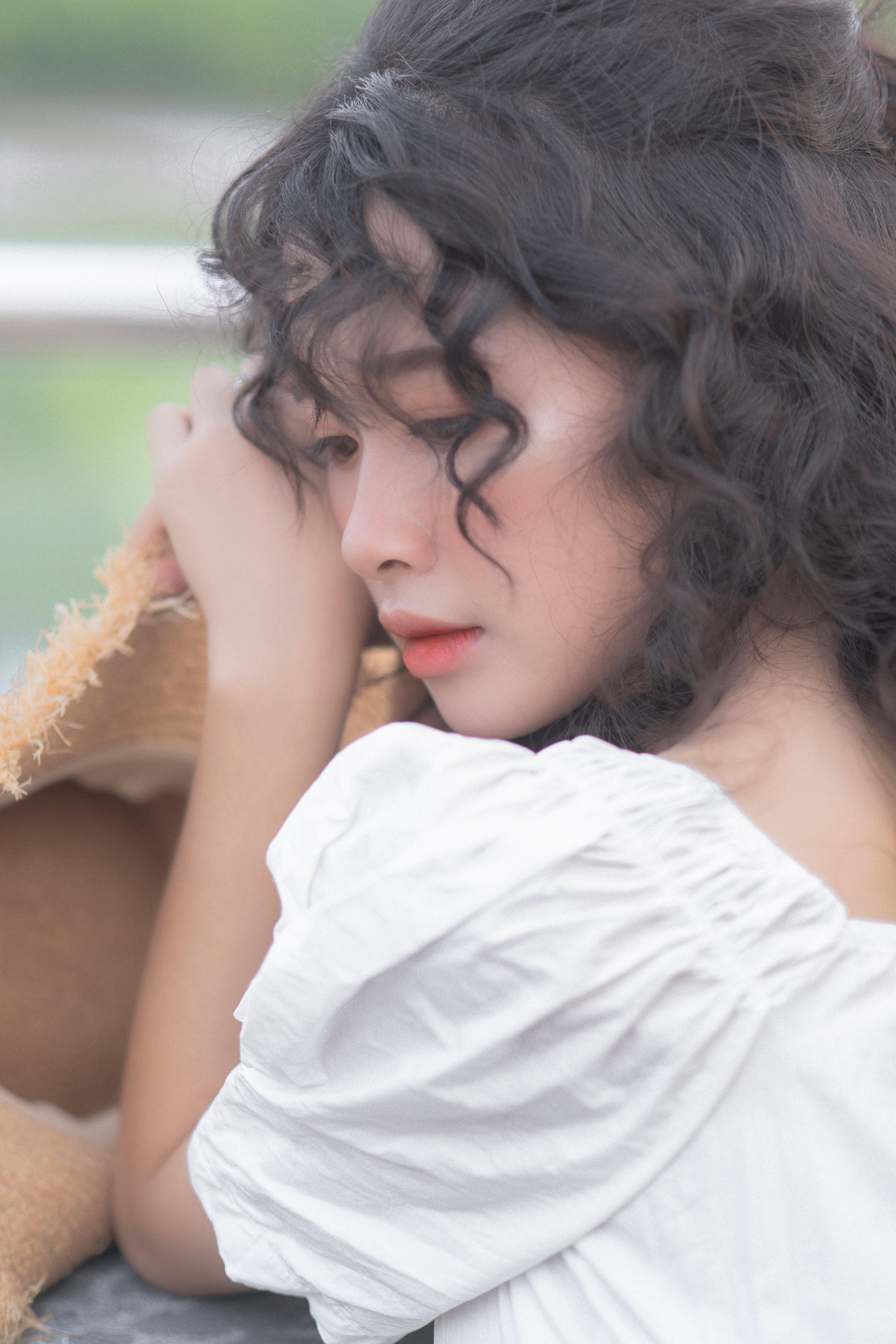Young Woman in White Dress with Curly Hair · Free Stock Photo