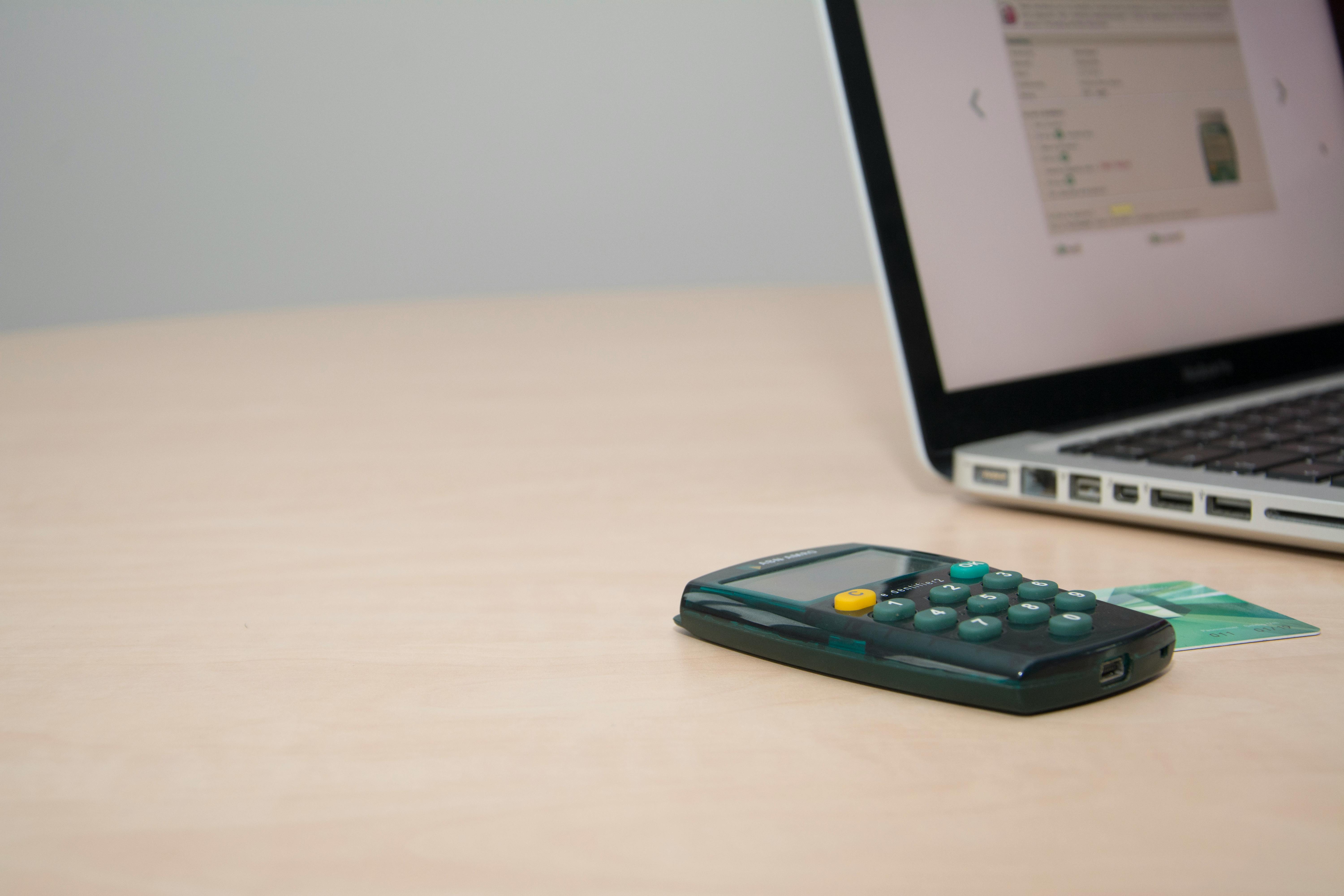 calculator and a credit card next to a laptop