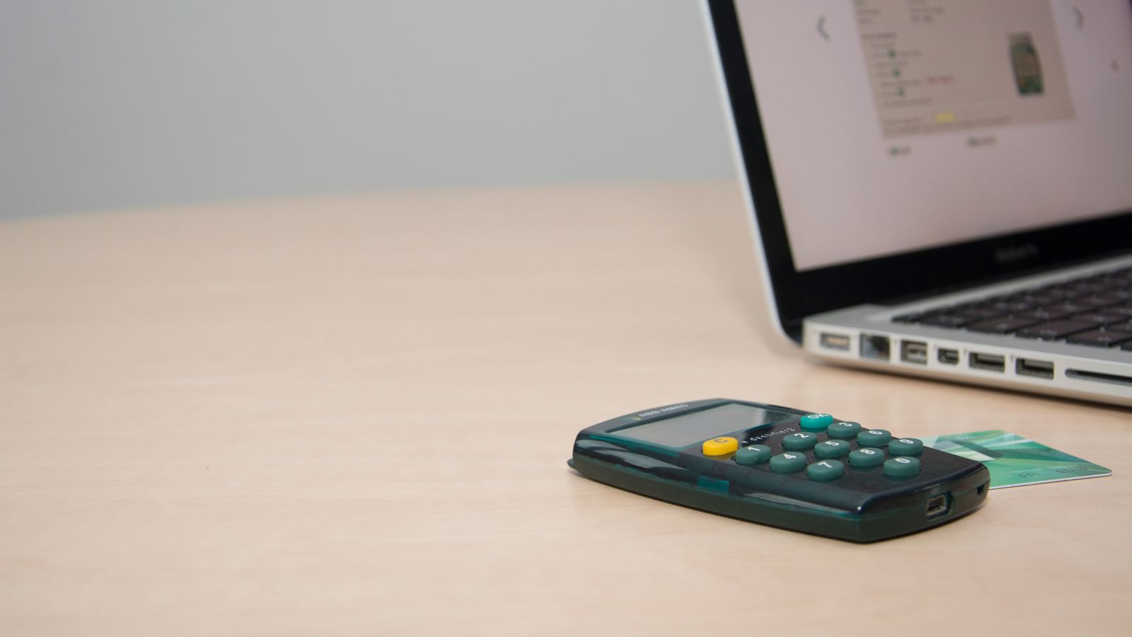 Calculadora, tarjeta bancaria y portátil sobre una mesa