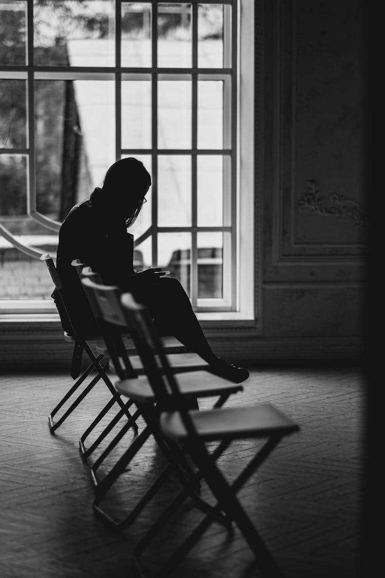 Silhouette Of Woman Sitting On A Chair