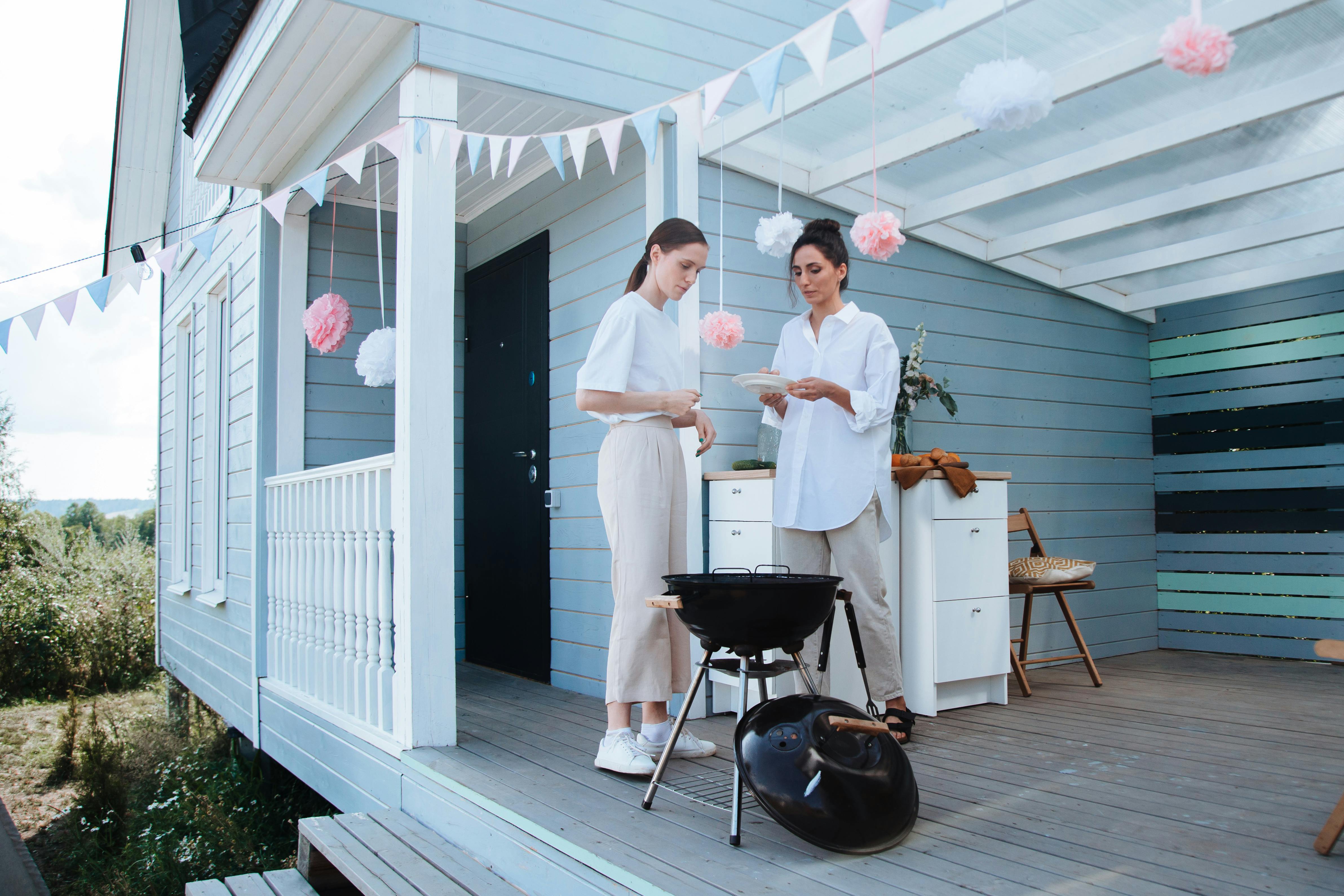 women standing on a terrace while grilling food