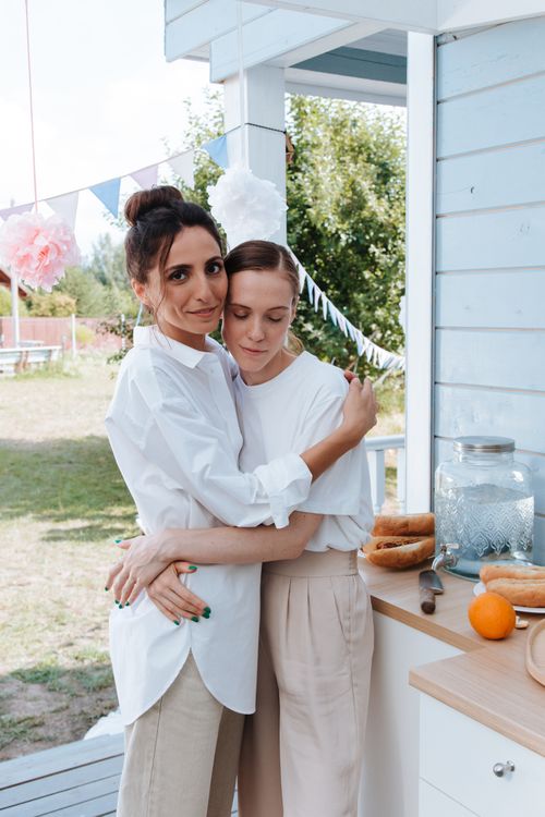 Free Two women embracing in an outdoor setting during a casual summer gathering. Stock Photo