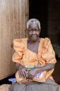 Photo of a Woman Sitting Near a Wooden Door