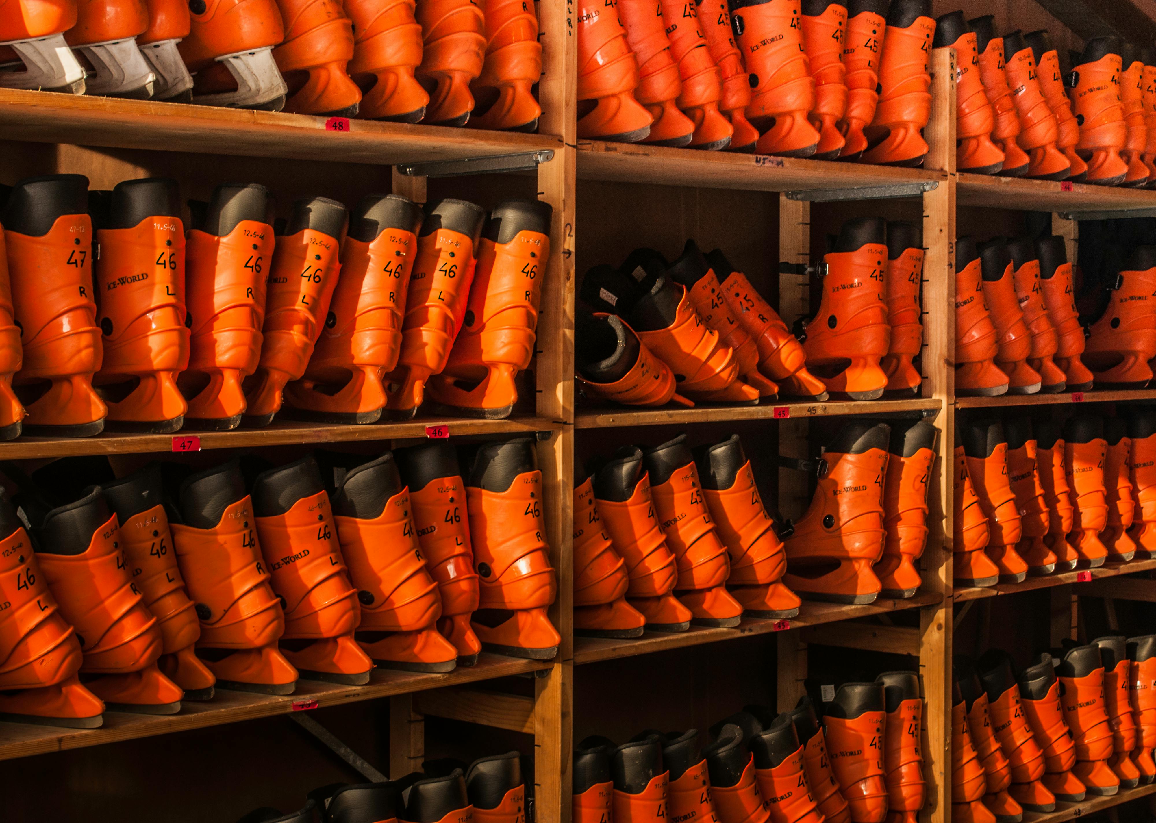 Orange Ice Skates on Wooden Shelves