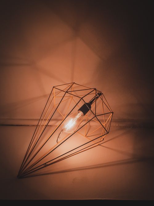 Free Stylish geometric light fixture casting warm glow, perfect for modern interiors. Stock Photo